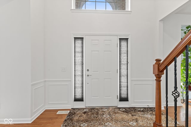 7350 Gold King Way, Indianapolis, IN 46259 - entrance foyer featuring a decorative wall, wood finished floors, a wainscoted wall, and stairway