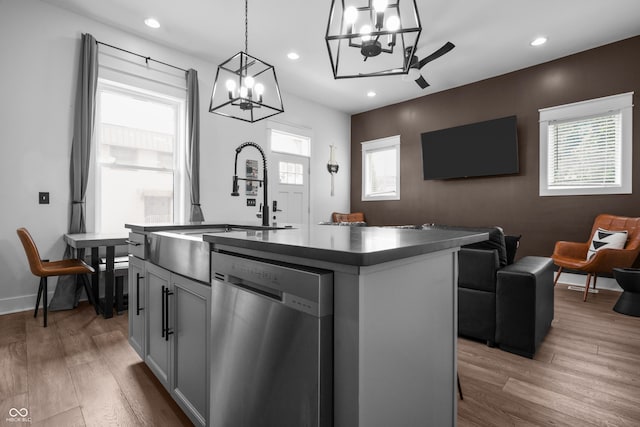 934 Calvary St, Indianapolis, IN 46203 - kitchen with dishwasher, a chandelier, a kitchen island with sink, open floor plan, and wood finished floors