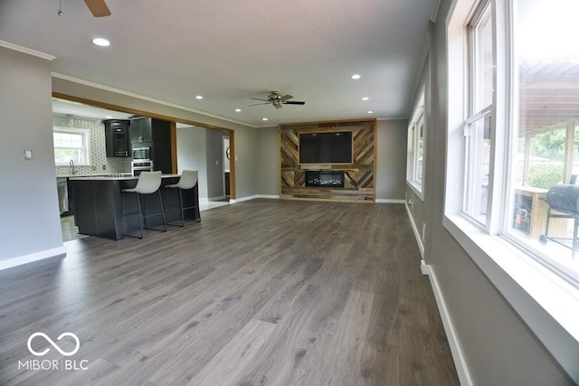 4430 Wexford Rd, Indianapolis, IN 46226 - unfurnished living room with ceiling fan, ornamental molding, dark wood finished floors, and recessed lighting