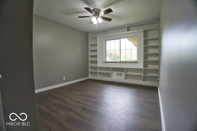 4430 Wexford Rd, Indianapolis, IN 46226 - spare room featuring dark wood-style floors, ceiling fan, a textured ceiling, and built in shelves