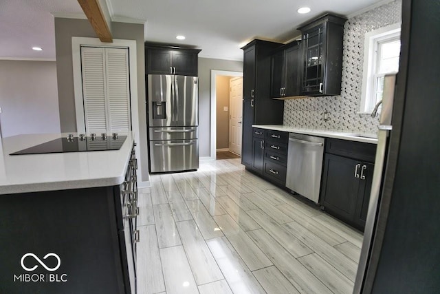 4430 Wexford Rd, Indianapolis, IN 46226 - kitchen with stainless steel appliances, ornamental molding, dark cabinets, light countertops, and backsplash