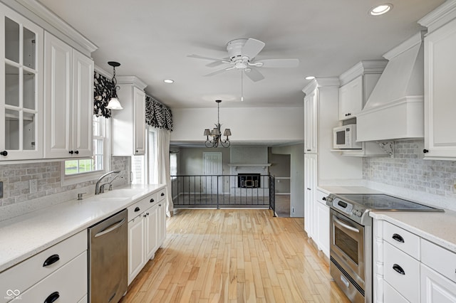 303 E County Road 500 N, Pittsboro, IN 46167 - kitchen with stainless steel appliances, custom range hood, white cabinetry, ceiling fan, and light countertops