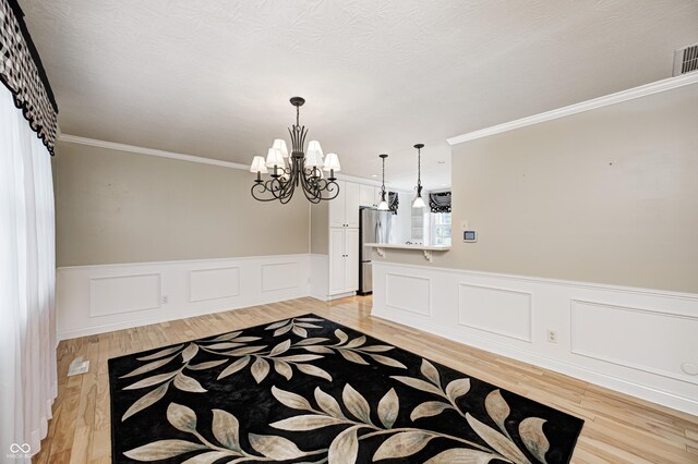 303 E County Road 500 N, Pittsboro, IN 46167 - entrance foyer featuring a chandelier, light wood finished floors, crown molding, and wainscoting
