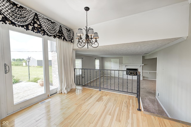 303 E County Road 500 N, Pittsboro, IN 46167 - spare room with wood finished floors, a chandelier, ornamental molding, and a brick fireplace