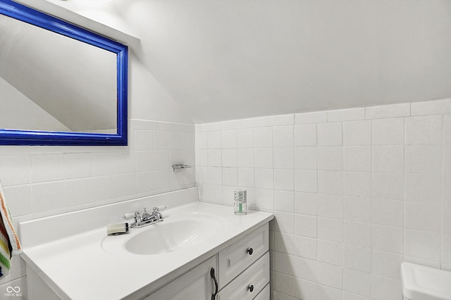 6430 E Southport Rd, Indianapolis, IN 46237 - bathroom featuring tile walls, vanity, and lofted ceiling