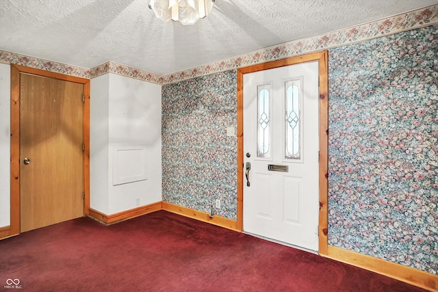 6430 E Southport Rd, Indianapolis, IN 46237 - foyer entrance with wallpapered walls, dark carpet, and a textured ceiling