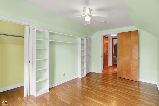 6430 E Southport Rd, Indianapolis, IN 46237 - unfurnished bedroom featuring wood finished floors, vaulted ceiling, multiple closets, and ceiling fan