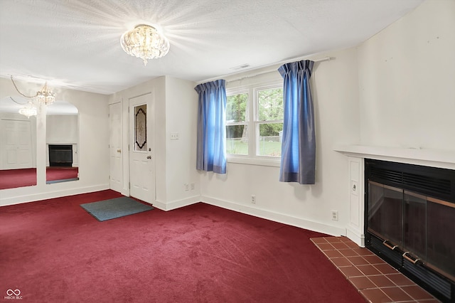 6430 E Southport Rd, Indianapolis, IN 46237 - unfurnished living room featuring a chandelier, a tile fireplace, and dark colored carpet