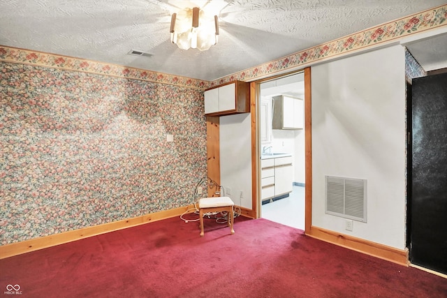 6430 E Southport Rd, Indianapolis, IN 46237 - spare room featuring a textured ceiling, carpet flooring, and wallpapered walls