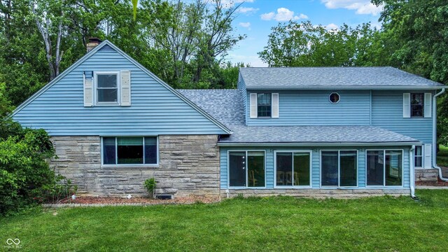 6430 E Southport Rd, Indianapolis, IN 46237 - back of house featuring a lawn, stone siding, roof with shingles, and a chimney