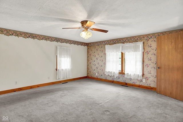 6430 E Southport Rd, Indianapolis, IN 46237 - carpeted empty room with healthy amount of natural light, ceiling fan, wallpapered walls, and a textured ceiling