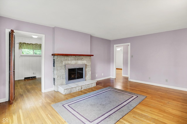 6430 E Southport Rd, Indianapolis, IN 46237 - unfurnished living room featuring hardwood / wood-style floors and a stone fireplace