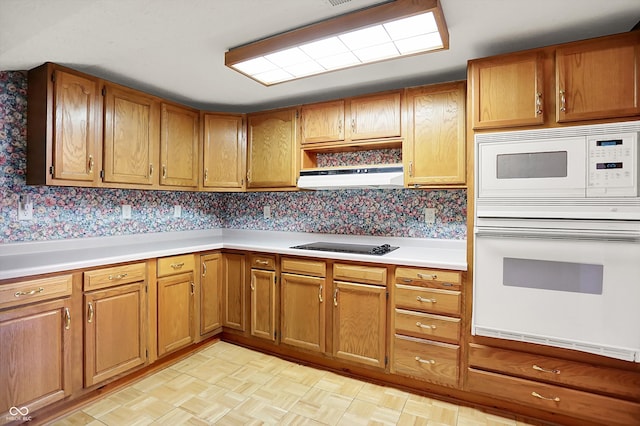 6430 E Southport Rd, Indianapolis, IN 46237 - kitchen with white appliances, light countertops, brown cabinetry, and extractor fan