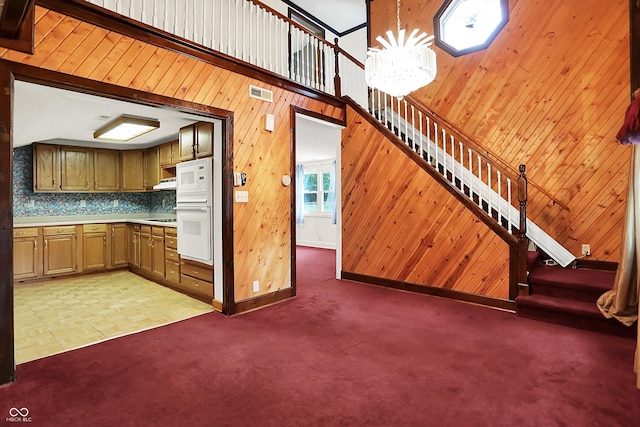 6430 E Southport Rd, Indianapolis, IN 46237 - kitchen featuring wood walls, light colored carpet, a chandelier, light countertops, and white microwave