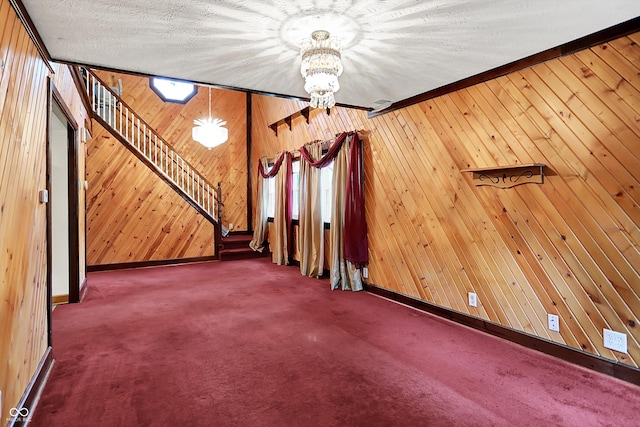 6430 E Southport Rd, Indianapolis, IN 46237 - unfurnished living room featuring a chandelier, wooden walls, carpet, and stairs