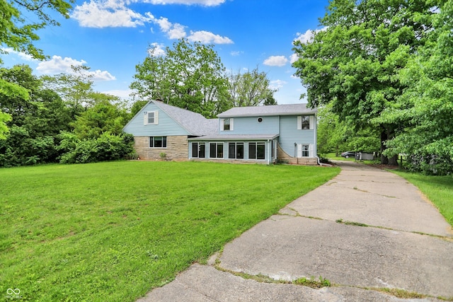 6430 E Southport Rd, Indianapolis, IN 46237 - back of property with a lawn, stone siding, and concrete driveway