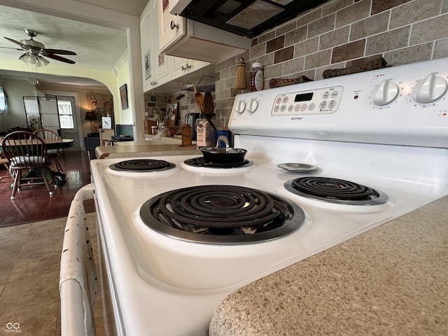 1433 N Colorado Ave, Indianapolis, IN 46201 - kitchen with white electric range, white cabinets, backsplash, a ceiling fan, and arched walkways