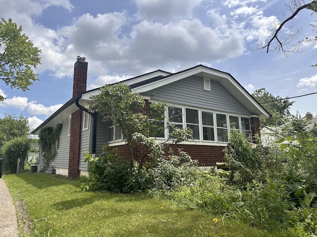 1433 N Colorado Ave, Indianapolis, IN 46201 - view of home's exterior featuring a chimney, a yard, and brick siding