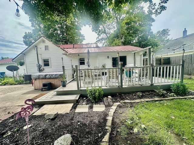 208 10th St, Covington, IN 47932 - rear view of property with a hot tub, a metal roof, and a wooden deck