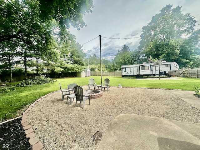 208 10th St, Covington, IN 47932 - fenced backyard featuring a storage shed and an outdoor fire pit