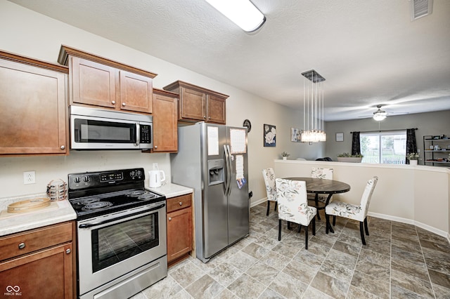 1331 Mccormicks Cir, Danville, IN 46122 - kitchen with stainless steel appliances, stone finish floors, light countertops, and brown cabinets