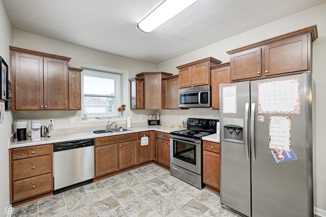1331 Mccormicks Cir, Danville, IN 46122 - kitchen featuring appliances with stainless steel finishes, light countertops, stone finish flooring, and brown cabinetry