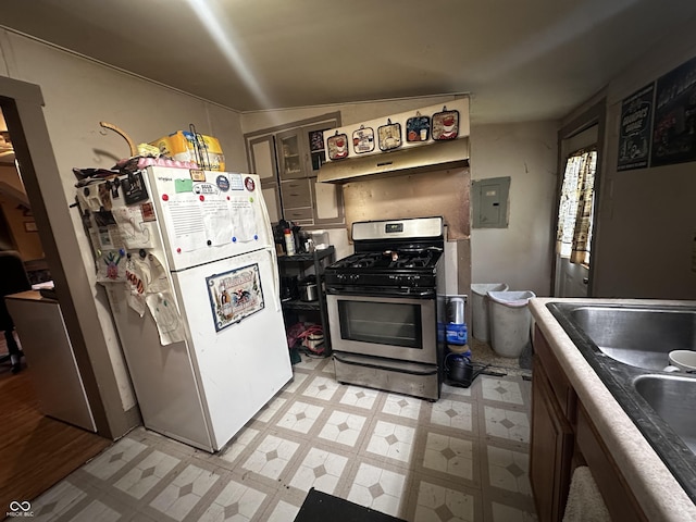 1033 S Locke St, Kokomo, IN 46902 - kitchen with stainless steel range with gas stovetop, freestanding refrigerator, electric panel, light floors, and glass insert cabinets