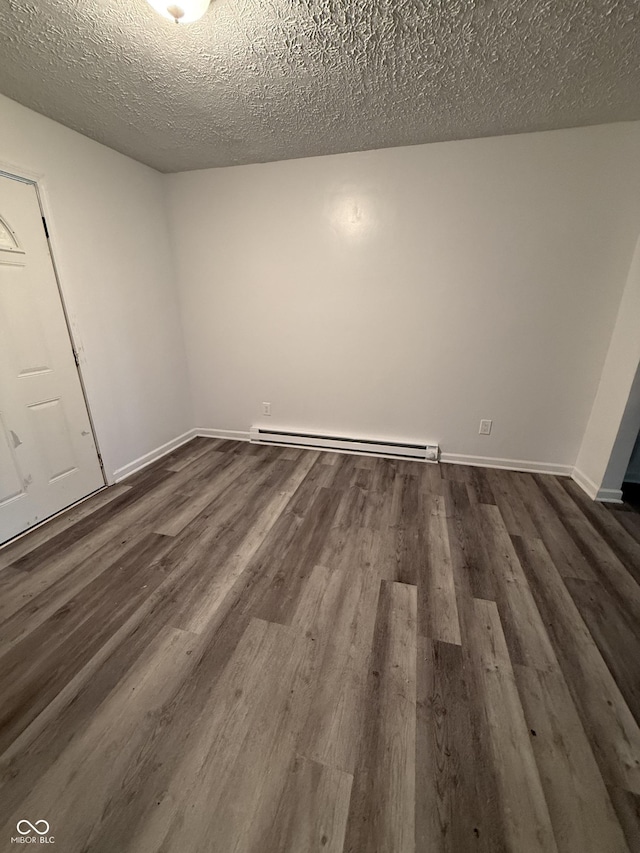 8434 Meadowlark Dr, Indianapolis, IN 46226 - spare room with a baseboard heating unit, dark wood-style flooring, and a textured ceiling