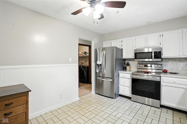 610 Front Royal Dr, Indianapolis, IN 46227 - kitchen with appliances with stainless steel finishes, washer / dryer, light countertops, a ceiling fan, and a wainscoted wall