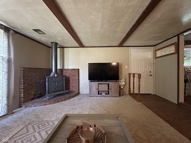 1908 Tennyson Dr, Clarksville, IN 47129 - carpeted living room featuring a textured ceiling, a wood stove, and beam ceiling