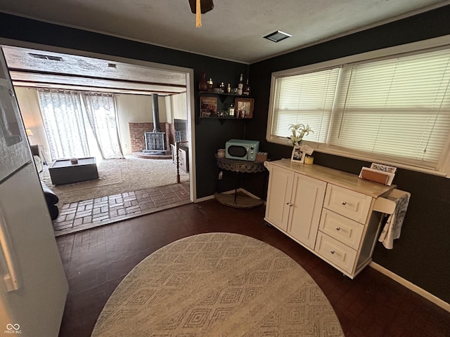 1908 Tennyson Dr, Clarksville, IN 47129 - home office featuring a wood stove, healthy amount of natural light, and dark wood-style floors