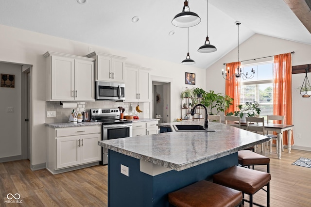 320 Briar Hill Dr, Whiteland, IN 46184 - kitchen with stainless steel appliances, a center island with sink, a kitchen bar, backsplash, and lofted ceiling