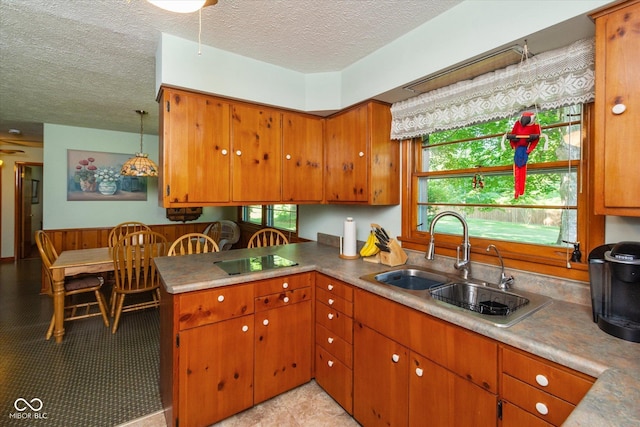 2808 Woodside Dr, Plainfield, IN 46168 - kitchen with a textured ceiling, black electric cooktop, brown cabinets, and plenty of natural light
