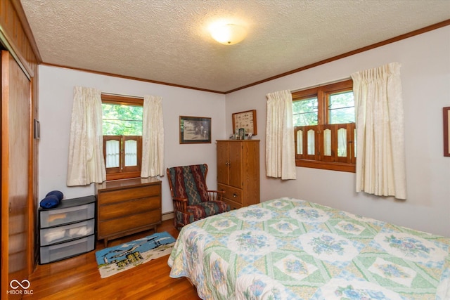 2808 Woodside Dr, Plainfield, IN 46168 - bedroom featuring wood finished floors, ornamental molding, a textured ceiling, a closet, and a baseboard heating unit