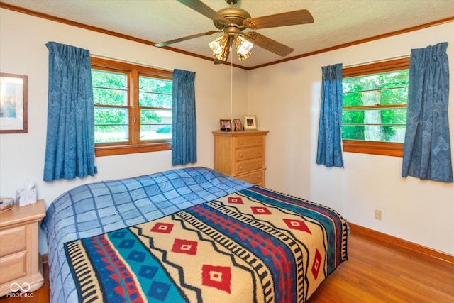 2808 Woodside Dr, Plainfield, IN 46168 - bedroom with wood finished floors, multiple windows, ceiling fan, a textured ceiling, and crown molding