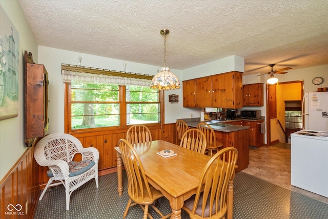 2808 Woodside Dr, Plainfield, IN 46168 - dining area with wainscoting, a ceiling fan, a textured ceiling, and wooden walls