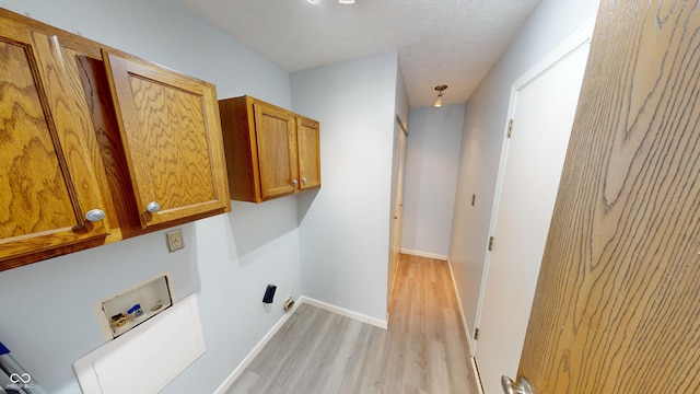 6640 Chipping Ct, Indianapolis, IN 46268 - laundry room featuring washer hookup, cabinet space, light wood finished floors, and a textured ceiling