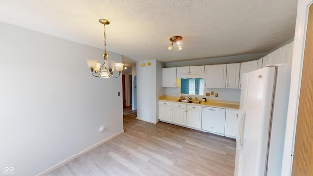 6640 Chipping Ct, Indianapolis, IN 46268 - kitchen with white appliances, light wood-style flooring, white cabinets, a chandelier, and light countertops