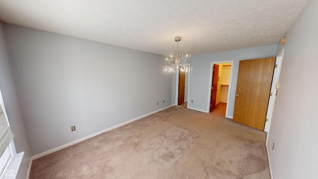 6640 Chipping Ct, Indianapolis, IN 46268 - unfurnished room featuring carpet flooring, a chandelier, and a textured ceiling