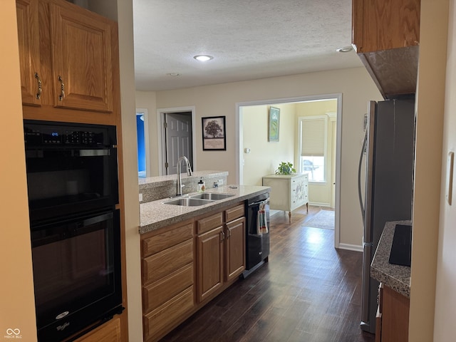 1626 N Nieman Dr, Greensburg, IN 47240 - kitchen featuring black appliances, brown cabinetry, a peninsula, dark wood-style flooring, and a textured ceiling