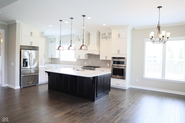 13044 Moorland Ln, Carmel, IN 46074 - kitchen featuring appliances with stainless steel finishes, premium range hood, light countertops, tasteful backsplash, and glass insert cabinets