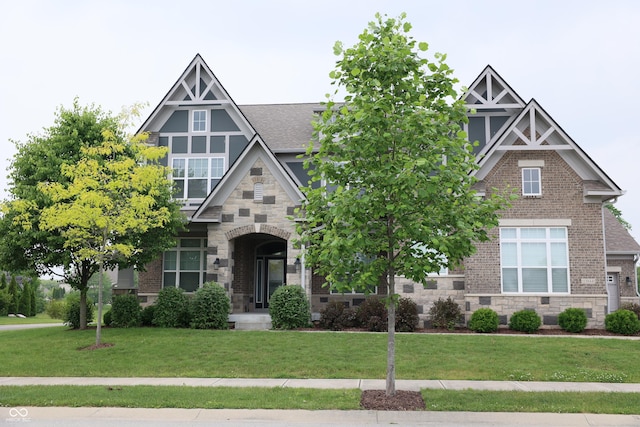 13044 Moorland Ln, Carmel, IN 46074 - view of front of house featuring stone siding, a front lawn, a shingled roof, and brick siding