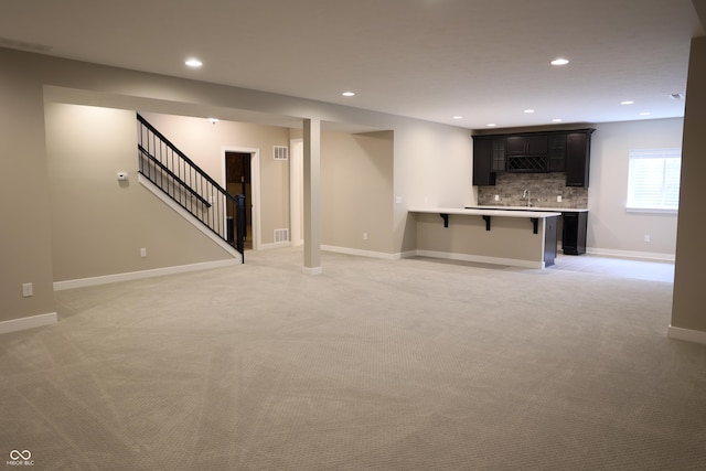 13044 Moorland Ln, Carmel, IN 46074 - unfurnished living room with light carpet, wet bar, recessed lighting, and stairway