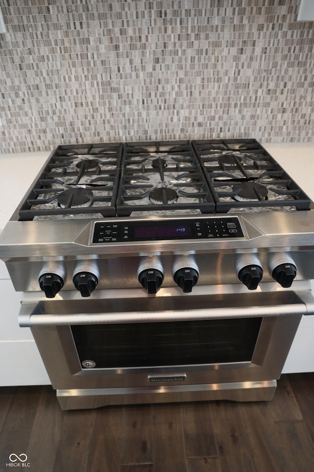 13044 Moorland Ln, Carmel, IN 46074 - kitchen view of high end stove, dark wood-type flooring, and tasteful backsplash