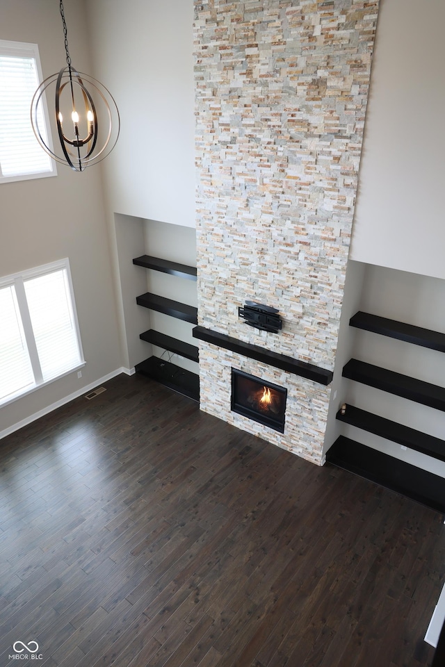 13044 Moorland Ln, Carmel, IN 46074 - unfurnished living room with a chandelier, dark wood finished floors, and a stone fireplace