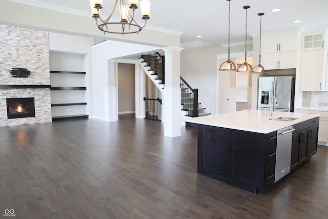 13044 Moorland Ln, Carmel, IN 46074 - kitchen with stainless steel appliances, open floor plan, light countertops, dark wood-type flooring, and ornamental molding