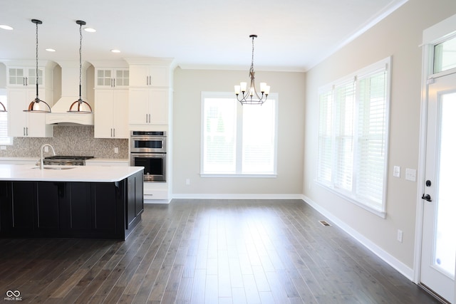 13044 Moorland Ln, Carmel, IN 46074 - kitchen with stainless steel double oven, light countertops, a chandelier, glass insert cabinets, and ornamental molding