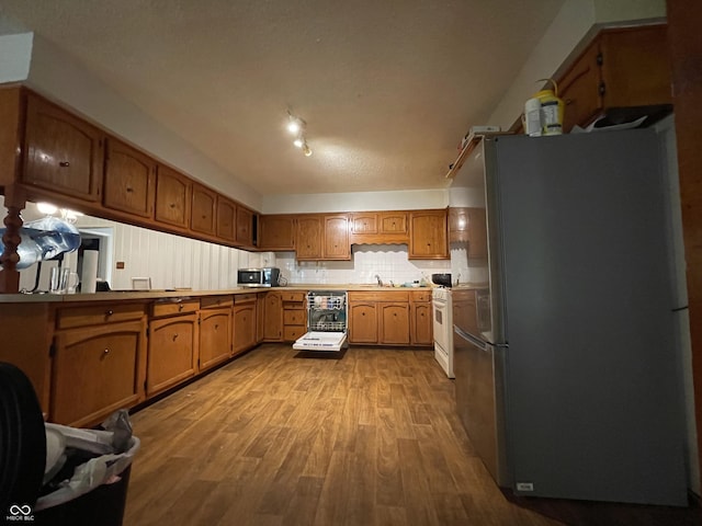 7725 S Oak Dr, Indianapolis, IN 46227 - kitchen featuring freestanding refrigerator, wood finished floors, brown cabinets, light countertops, and gas range gas stove