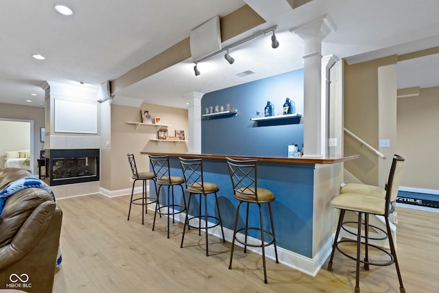 12214 Ridgeside Rd, Indianapolis, IN 46256 - indoor dry bar with light wood-type flooring, ornate columns, recessed lighting, and a tiled fireplace