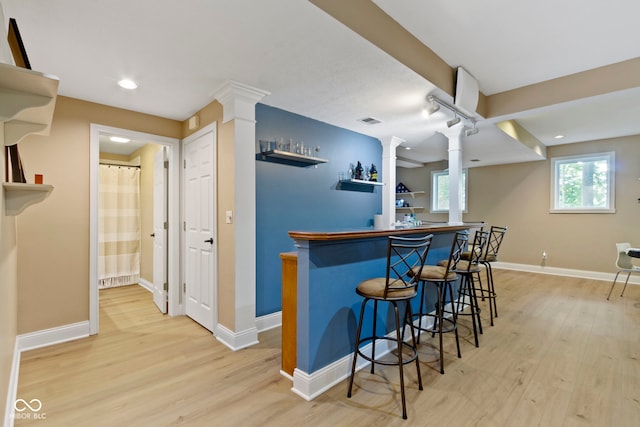 12214 Ridgeside Rd, Indianapolis, IN 46256 - kitchen featuring decorative columns, light wood-style flooring, a breakfast bar, and recessed lighting